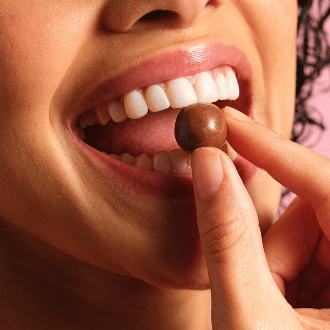 femme qui croque une perle chocolatée Nonna Choc, le 1er complément alimentaire au chocolat